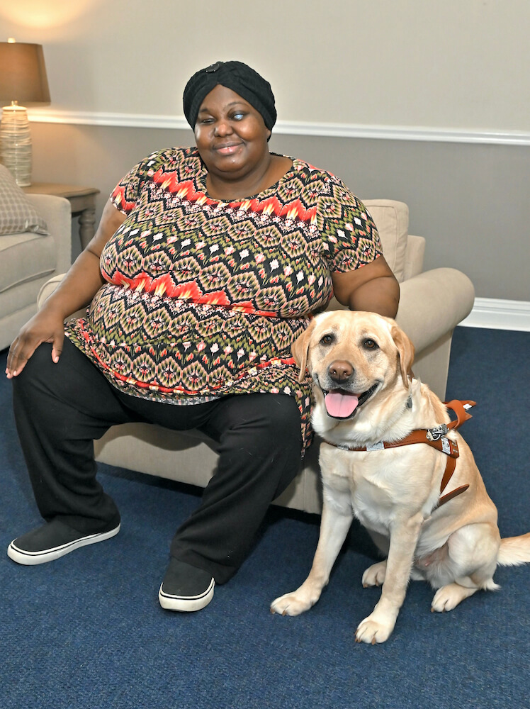 Jaydene in a beige chair, and Nita sit for their team portrait