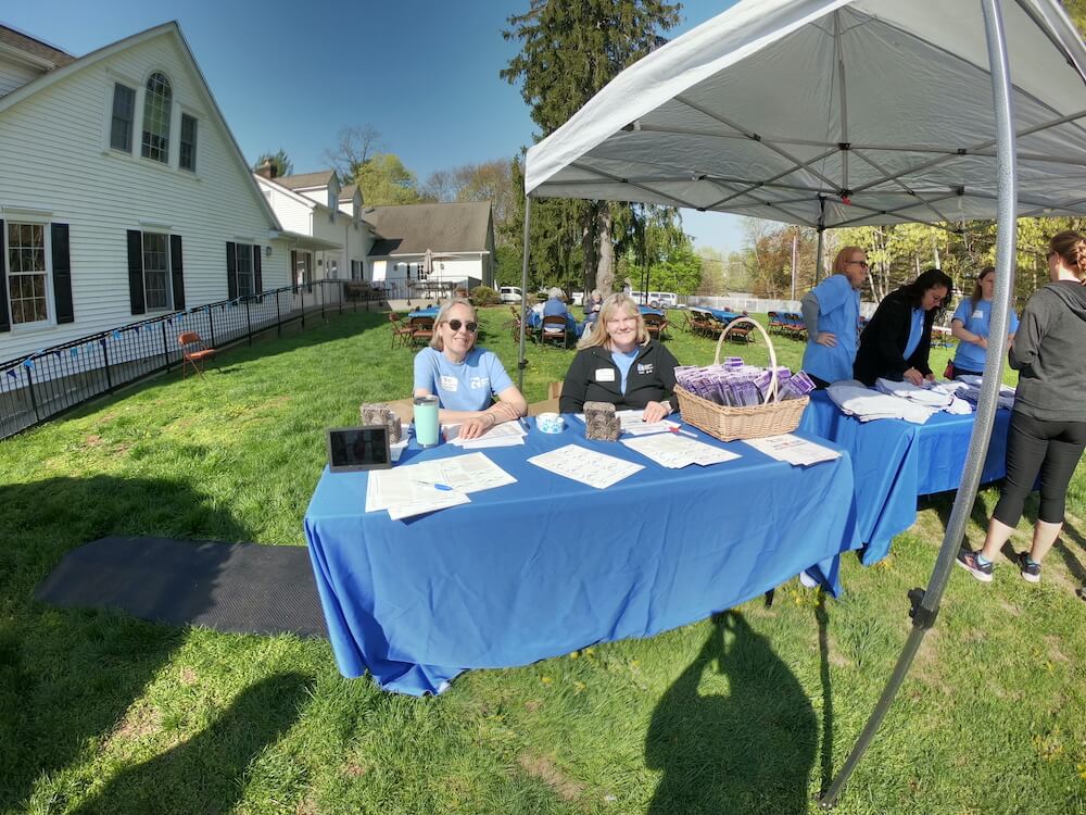 Pup Program's Ana and Leslie sit at an information table