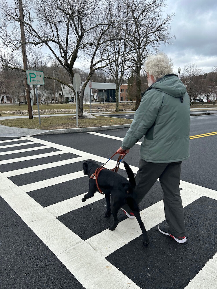 Dirk and Fernando walk quickly and safely through a white striped crosswalk