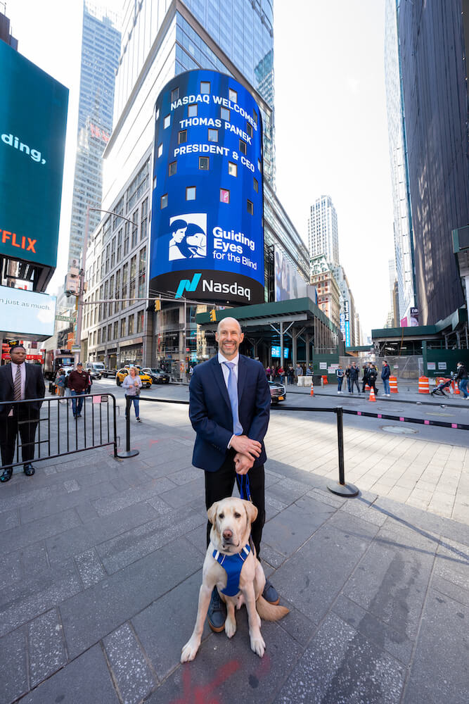 Thomas and Blaze in front of Nasdaq sign with GEB logo (Photography courtesy of Nasdaq, Inc)