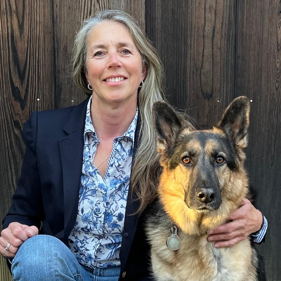 Laura Peterman Chief of Staff with adopted German Shepherd Nira in front of a barnwood wall