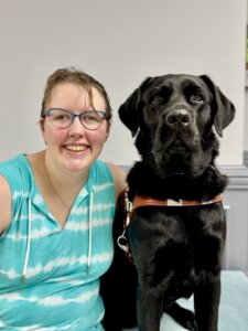 Lily sits head to head with black Lab guide dog Jax for their team portrait