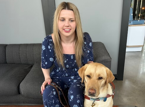 Morgayne and yellow guide dog Omega (Nala) sit together for a team portrait