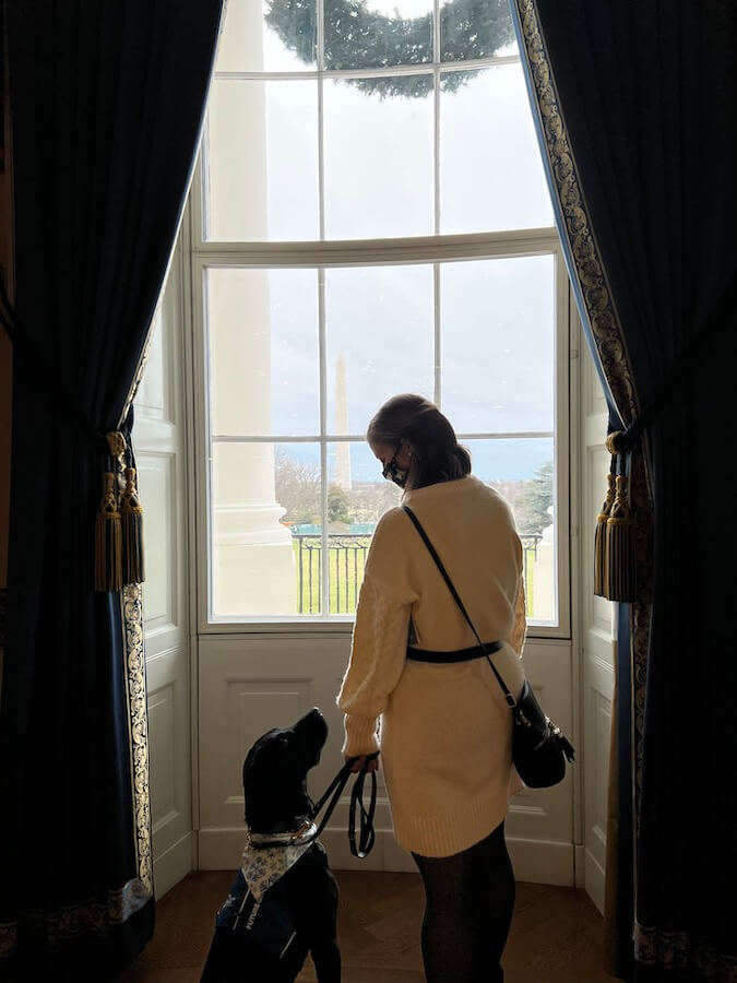 raiser and Kenneth look to each other at a White House window looking out at Washington Monument