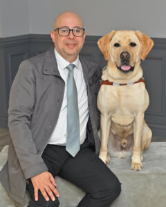 Gabriel and yellow Lab guide dog Gabe sit for team portrait