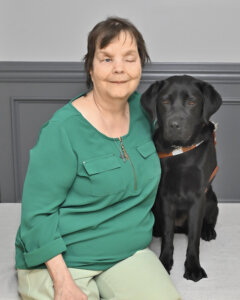 Arlene and black Lab Yardley sit side by side for formal graduate portrait