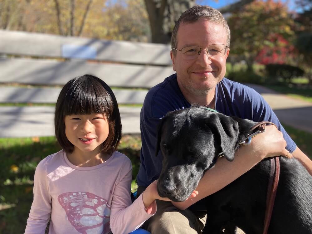 pup on program Reina poses with raiser dad and child