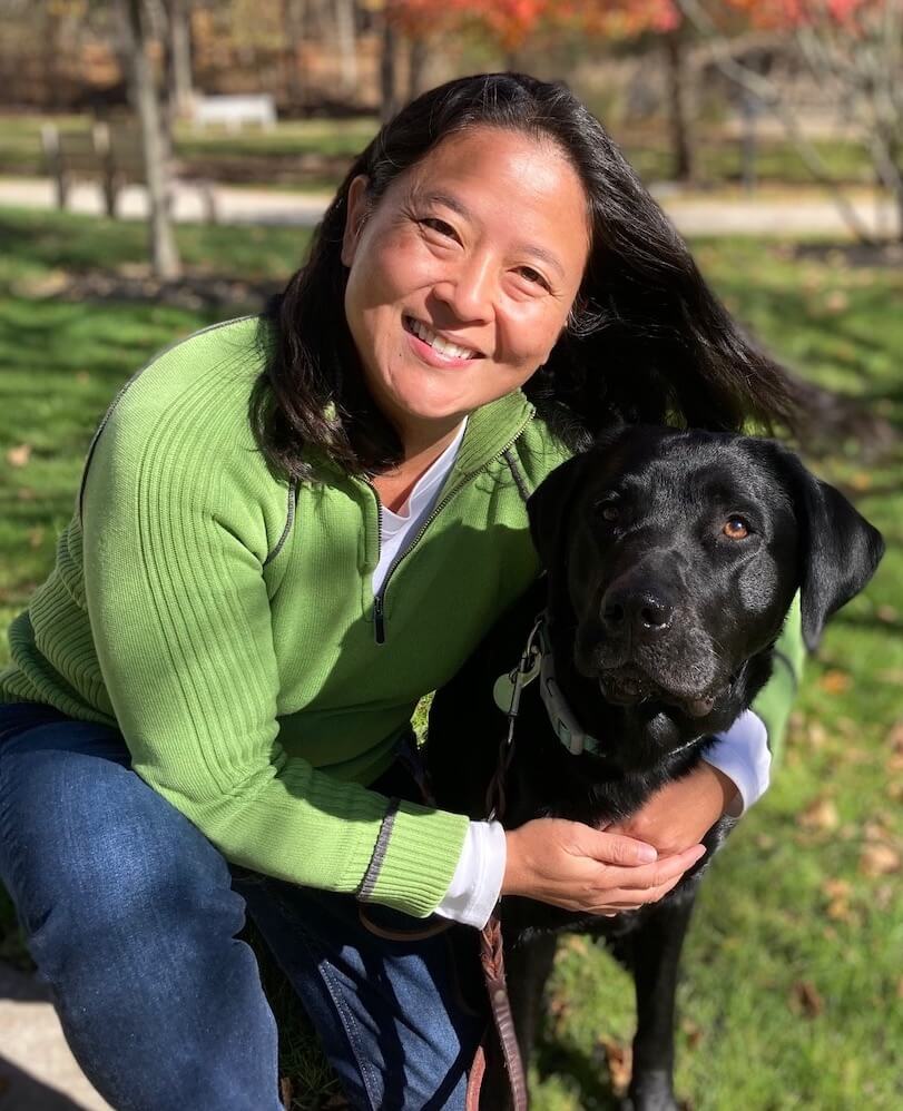 black lab Reina is hugged by his co-raiser Loring