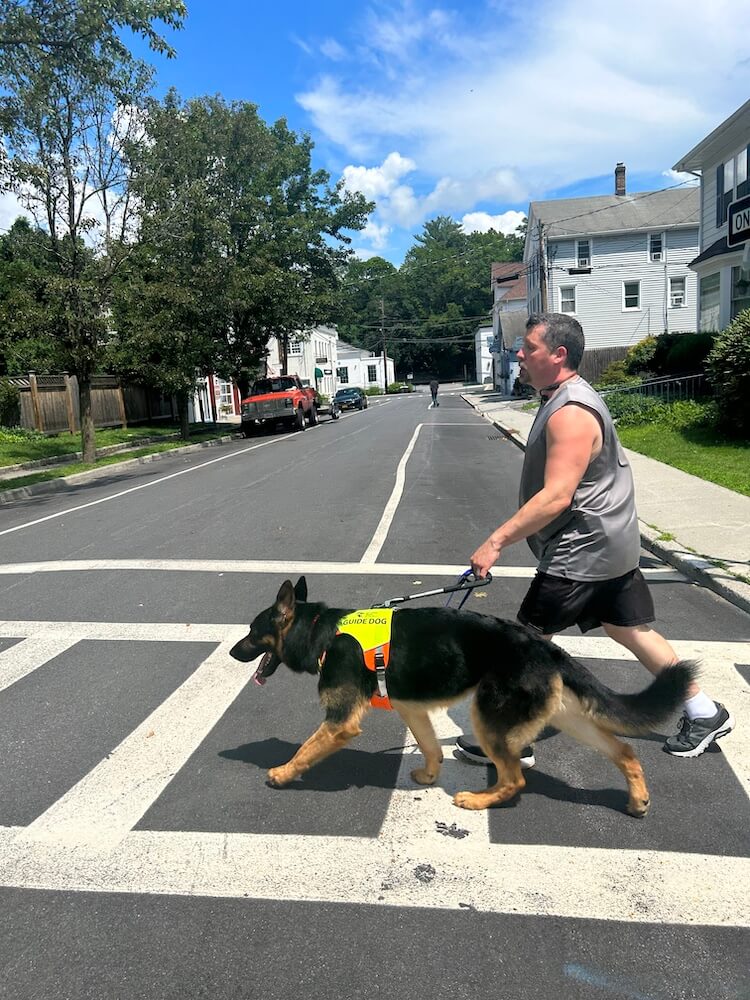 Kenn and Hobie cross a residential crosswalk at a quick pace