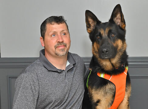 Kenn and german shepherd guide Hobie sit side by side for team portrait