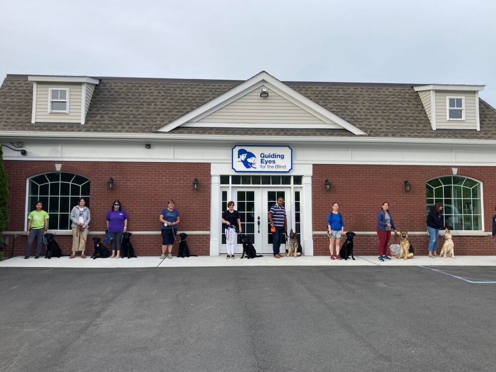 At the Guiding Eyes Outreach Center Fame and raiser stand in line with 6 others during class (2nd from right)
