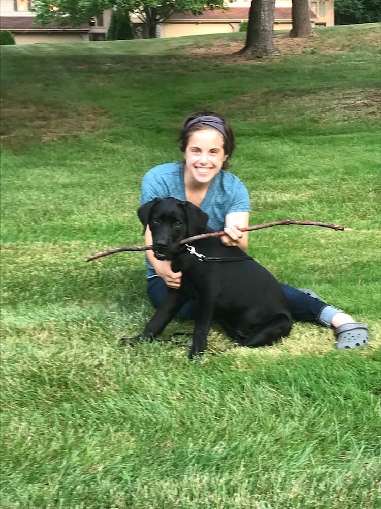 black lab Eve with young woman from her raiser family