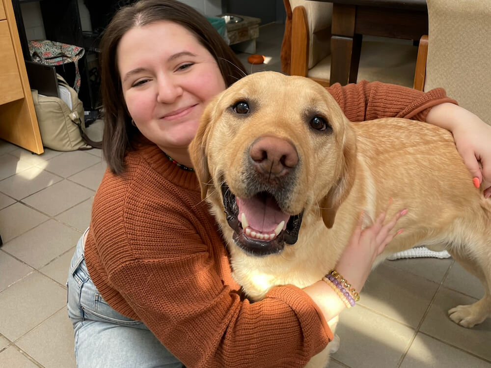 Yellow lab pup on program Jake with raiser Kat