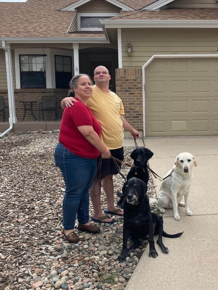 Judy Mathews with her husband, two guide dogs and a rescue pup.