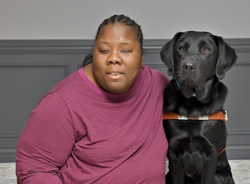 Dazia sits with black Lab guide dog Casey for their team portrait
