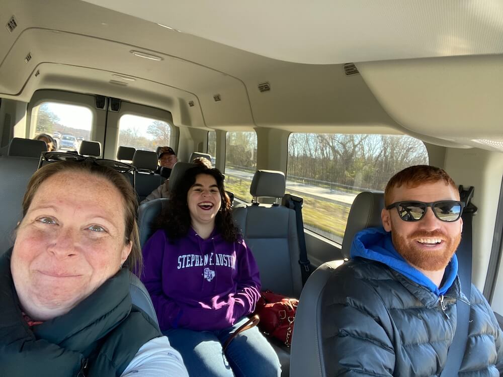 a selfie with instructors Michelle and Dan in the van with a laughing Mari behind them