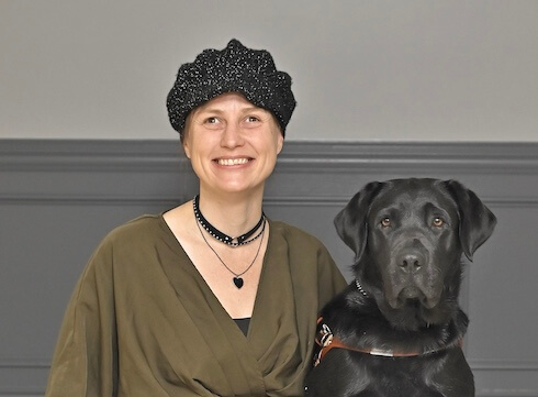 Misty sits with black Lab guide dog Penny for their team portrait
