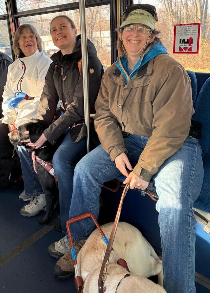 Stacy with classmates on a bus holding Vancouver's leash