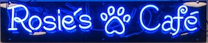 A bright neon sign says Rosie's Cafe with a paw print between the words