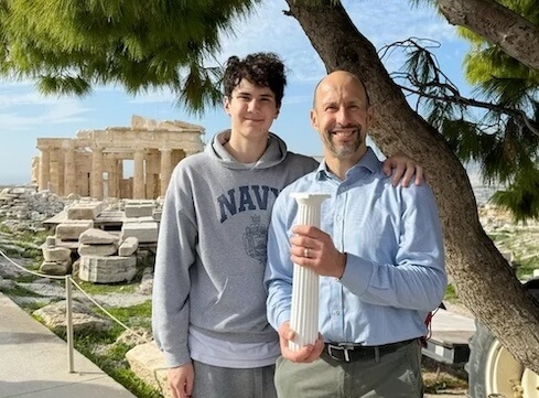 Thomas Panek, next to son Timothy, holds a replica of a Doric column against the backdrop of the Parthenon in Athens, Greece.