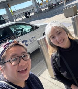 Meicy and Ivy selfie with GEB vehicle as they arrive in NYC