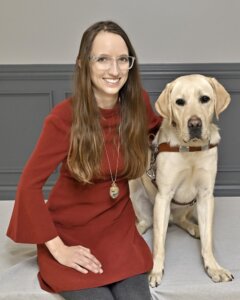 Shannon and her yellow  Lab guide dog MacGyver sit for their team portrait