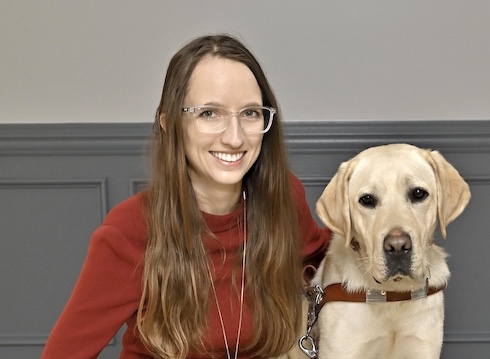 Shannon and her yellow Lab guide dog MacGyver sit for their team portrait