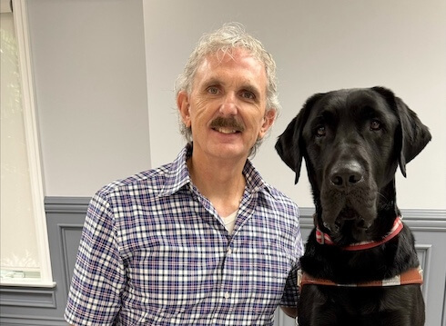 Randy and black lab guide dog Idaho sit for their team portrait