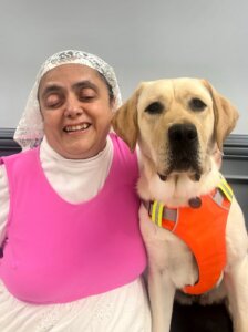 Ramsina and yellow Lab guide dog Arizona sit side by side for their team portrait