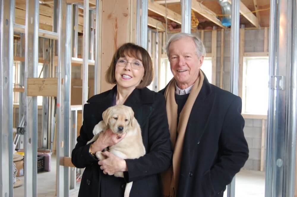 Bill Badge in a winter coat and scarf visits the shell of the Arthur Milton Breeding Kennel with benefactor Phyllis Milton