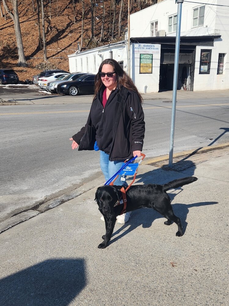 Tisha happily walks with Satya in the sunshine, past a modest auto repair shop