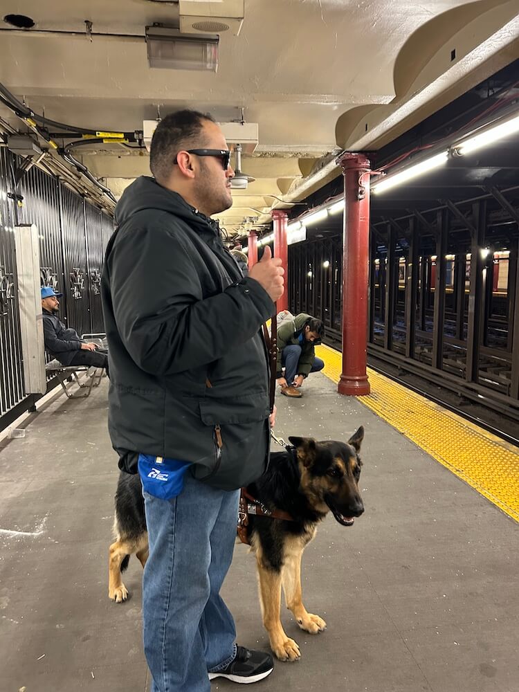 David and guide Woody stand waiting on a subway platform