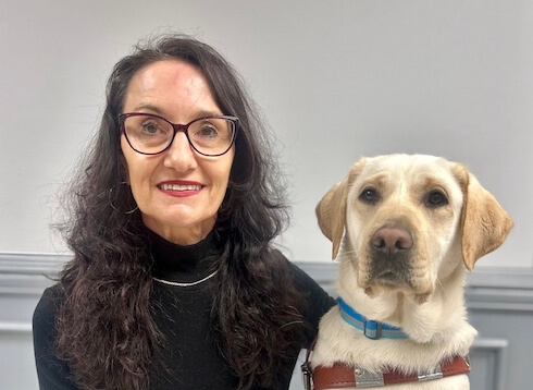 Nicole and her yellow Lab guide dog Glenda sit together for their team portrait