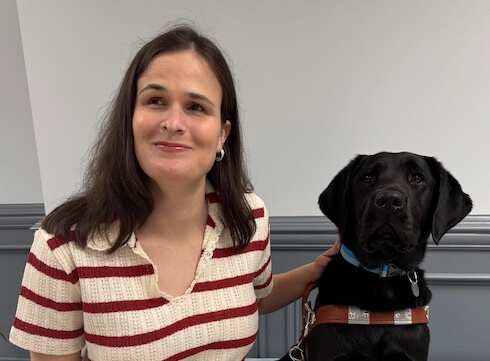 Maddie and black Lab guide dog Jackie sit side by side for their team portrait