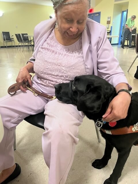 Sandra sits while Vega puts her head on her lap and Sandra talks to her