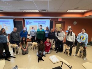 Group photo of nine puppy raisers-seven pups on program- Melissa-Meka-Nikki-Cindy and Laura