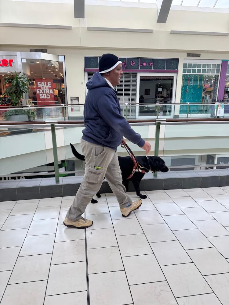 Amir and Irving walk confidently through the upper level of a mall
