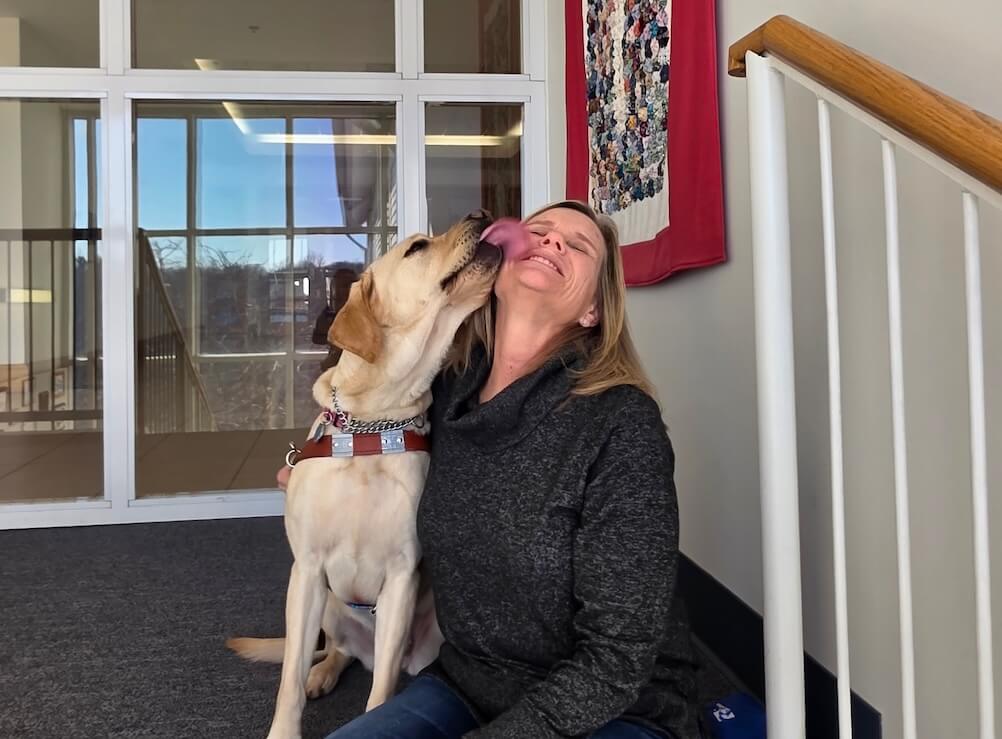 While posing for a portrait photo guide Mia surprises Carol with a big kiss to the face
