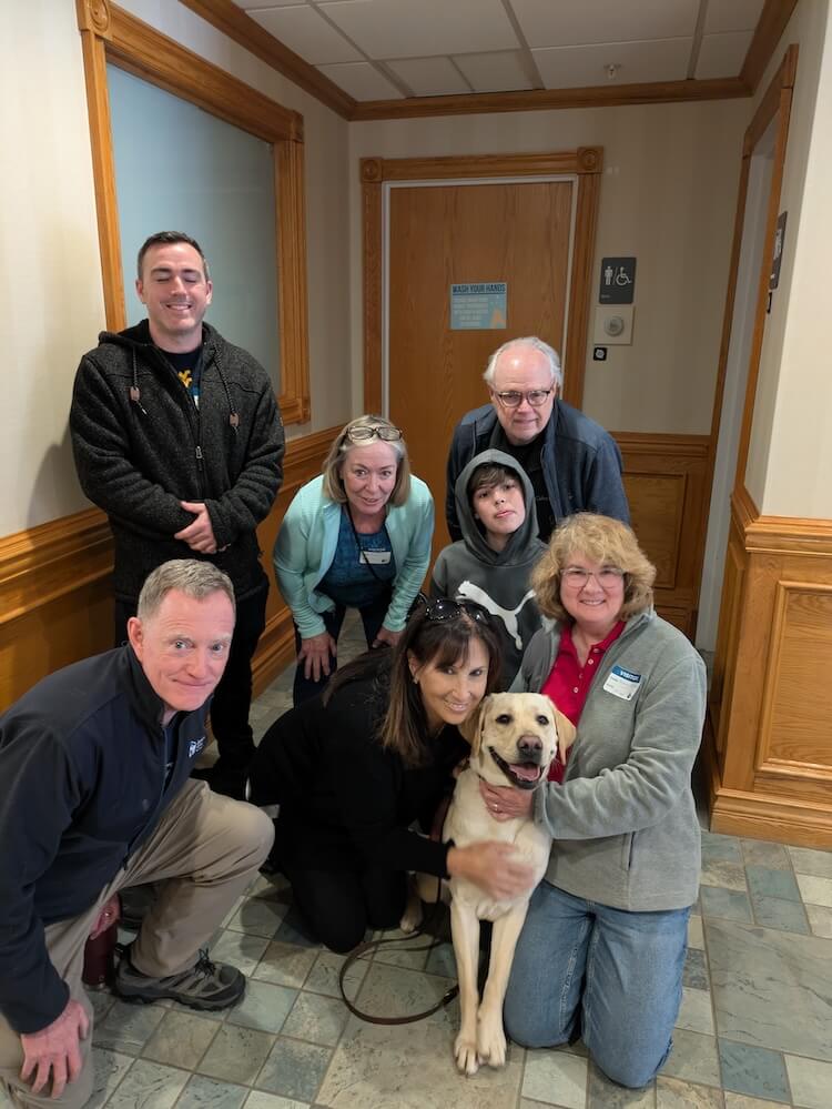 At her IFT, Mia poses in the training school hallway with her puppy raiser families