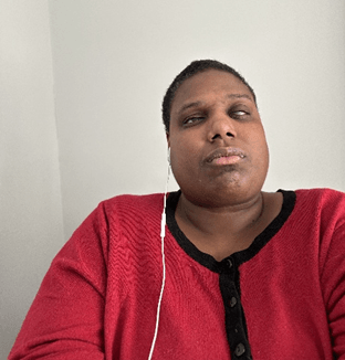 Meka takes a selfie, wearing a red sweater. 