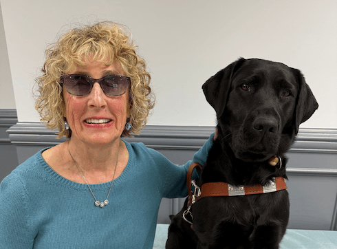 Wendy and black Lab guide dog July sit side by side for their team portrait