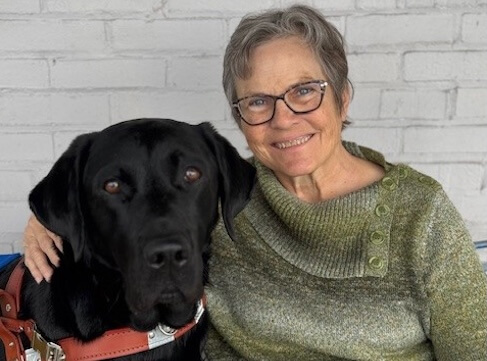 Jean and Abraham sit close against the backdrop of white brick for their team portrait