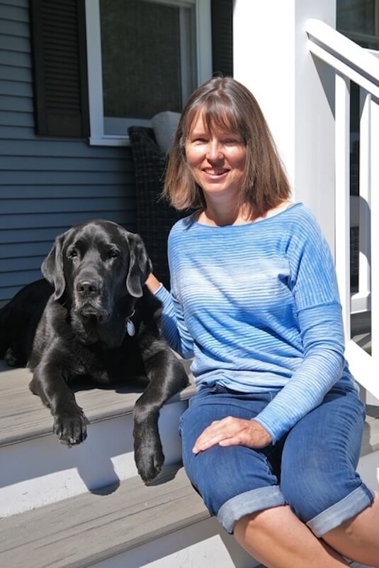 Lisa sits on a set of residential steps while Iron is in a down on the top step with paws hanging over