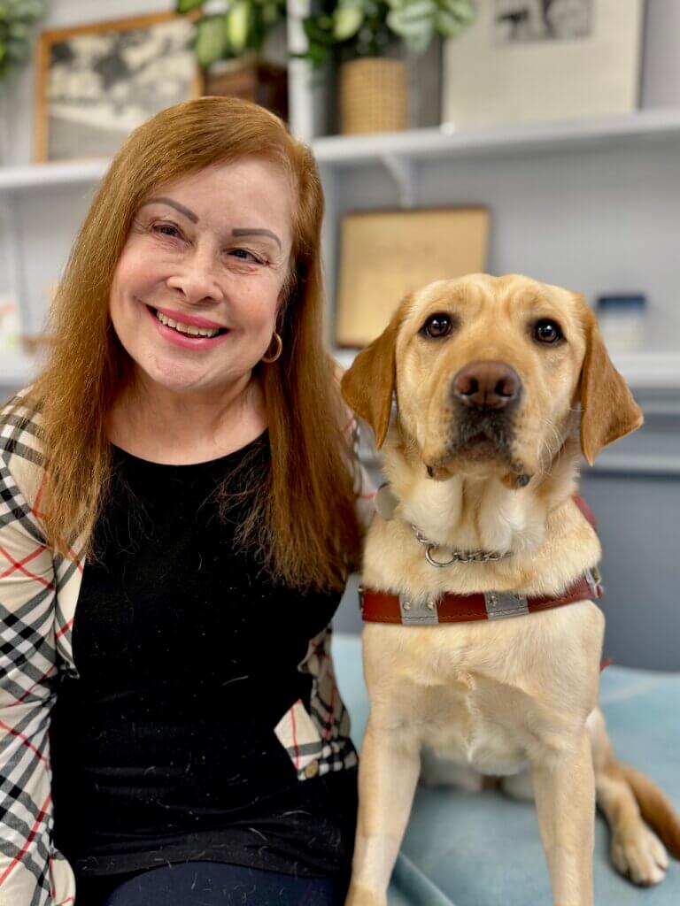 Vickia and yellow Lab guide do Bubbles sit together for their team portrait