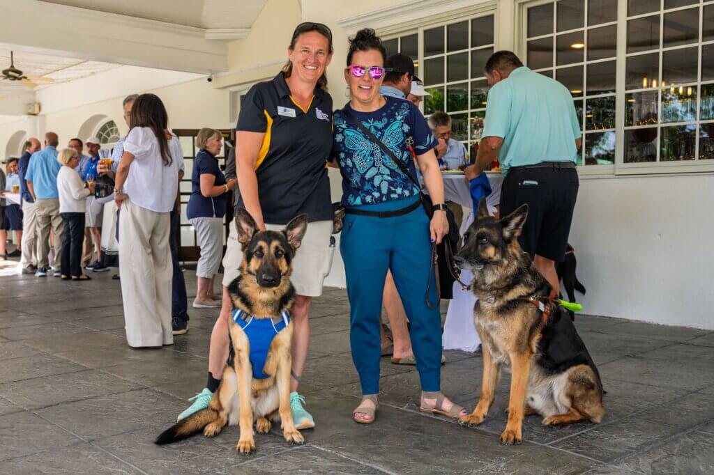 Jo with Steinway, male black and tan German Shepherd guide dog in training, with Shawn and guide dog Nick, male black and tan German Shepherd guide dog.