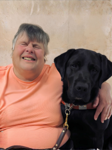Katherine and black Lab guide dog Morgan sit side by side for their team portrait