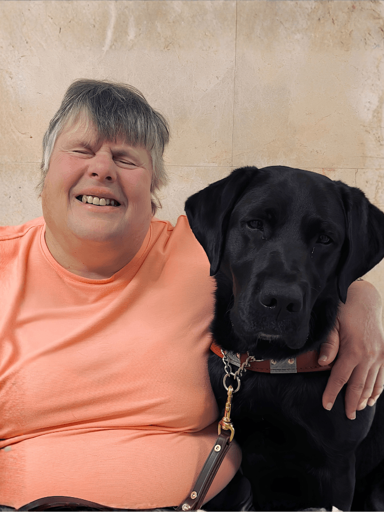 Katherine and black Lab guide dog Morgan sit side by side for their team portrait