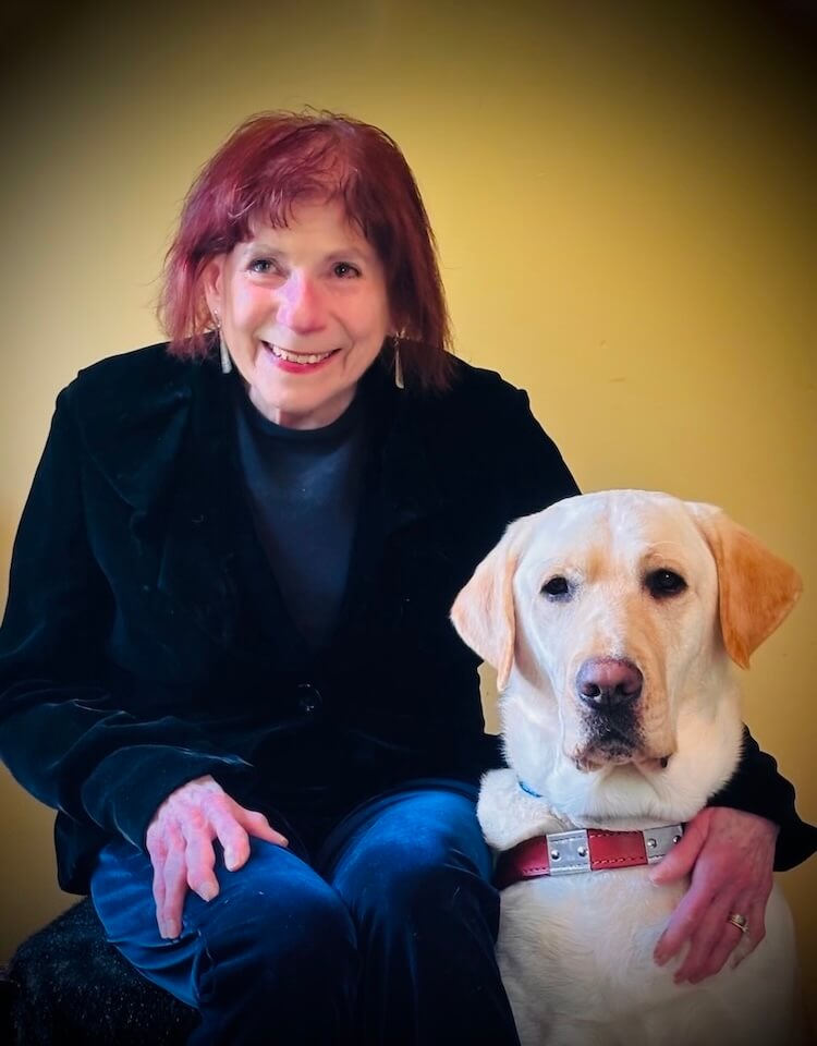 Janet and yellow guide dog Anderson, sit together for their team portrait
