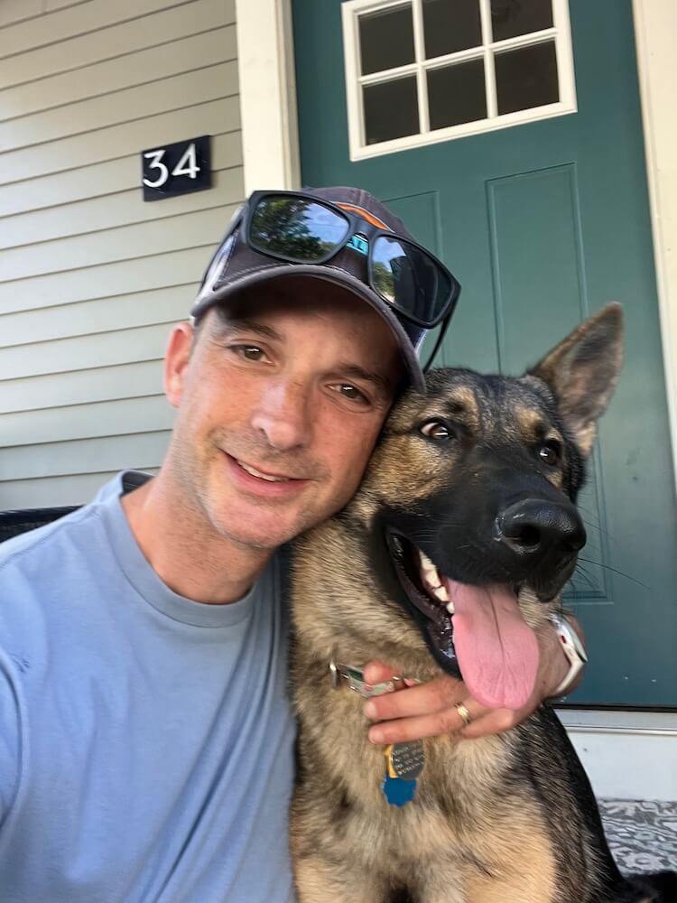 Pup on program German Shepherd Rose gets a hug sitting next to her puppy raiser