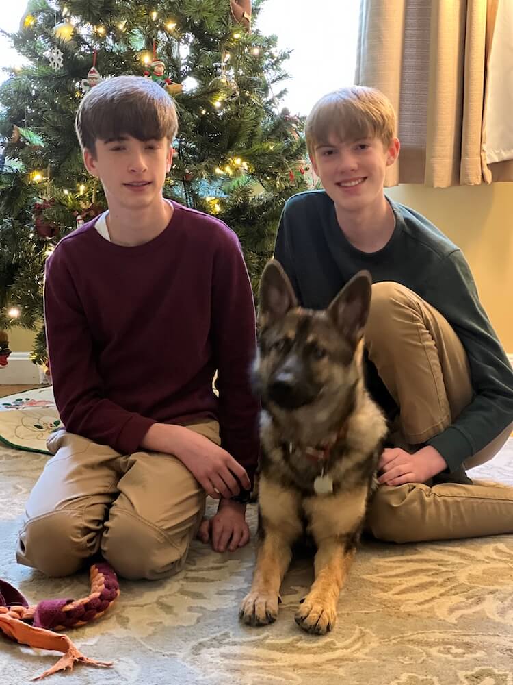 Rose poses by the Christmas tree with two boys from her raiser family